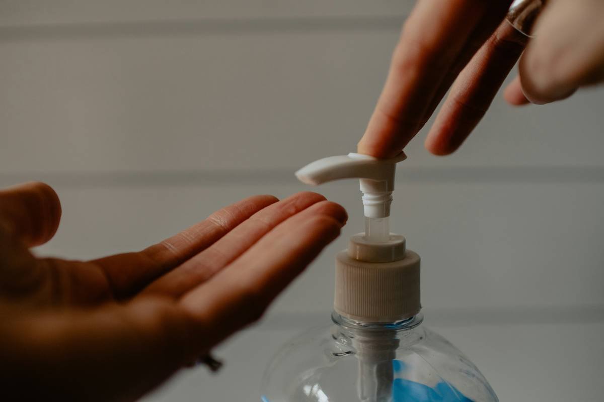 Close-up of hands massaging daily care moisturizer play everyday lotion into dry heels